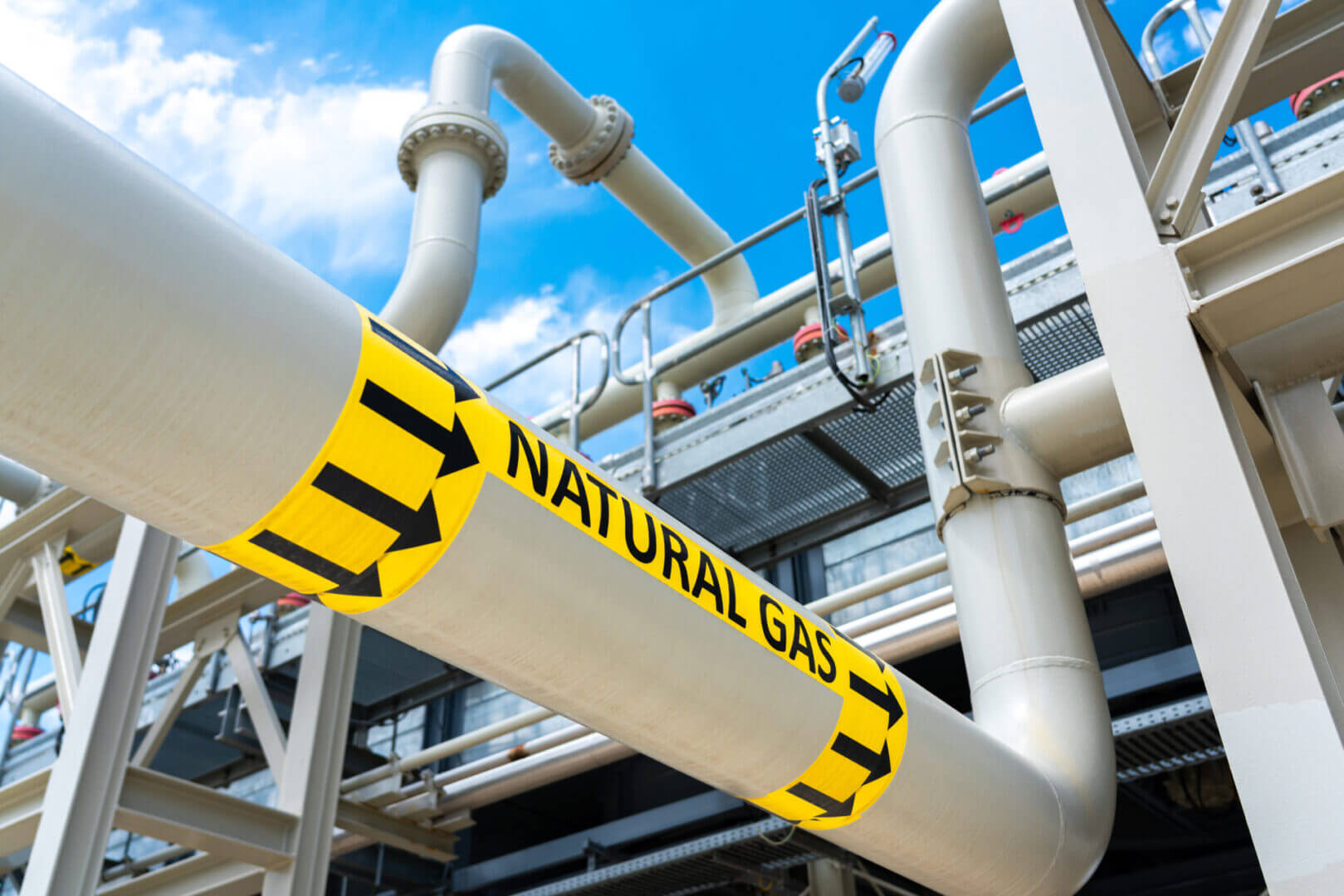Yellow pipeline labeled "Natural Gas" in an industrial setting.